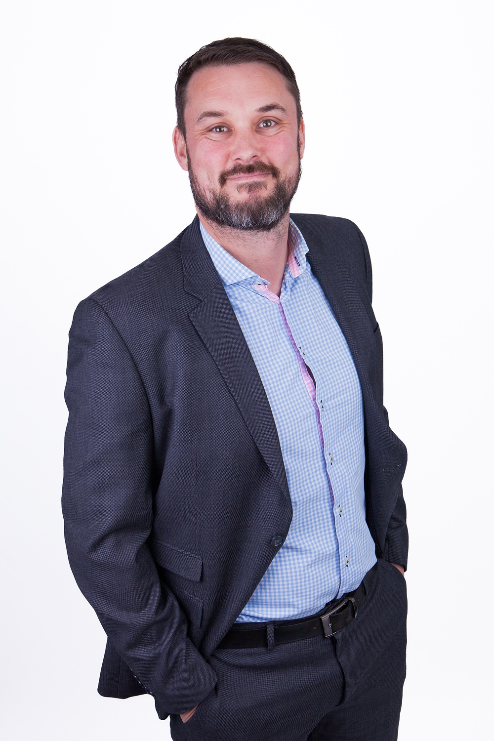 Samuel Hall in a suit, smiling at the camera